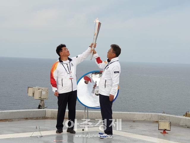 김생현 서울시의회 의장과 ㅇㅇㅇ 울릉군수가 성화봉을 높이 들어 채화 성공을 알렸다.