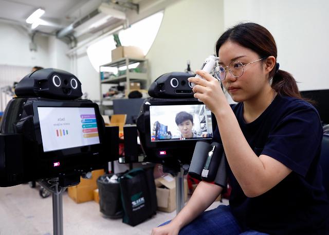 태국 방콕의 한 학생이 코로나19 확진자를 선별하고 관찰하기 위해 개발된 스마트 원격 의료 로봇을 시연하고 있다.