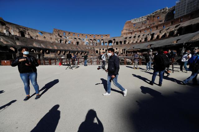 Journalists wearing protective face masks are seen at Rome's ancient Colosseum as it is being reopened with social distancing and hygiene measures in place after months of closure due to the spread of the coronavirus disease (COVID-19), in Rome, Italy June 1, 2020. REUTERS/Yara Nardi