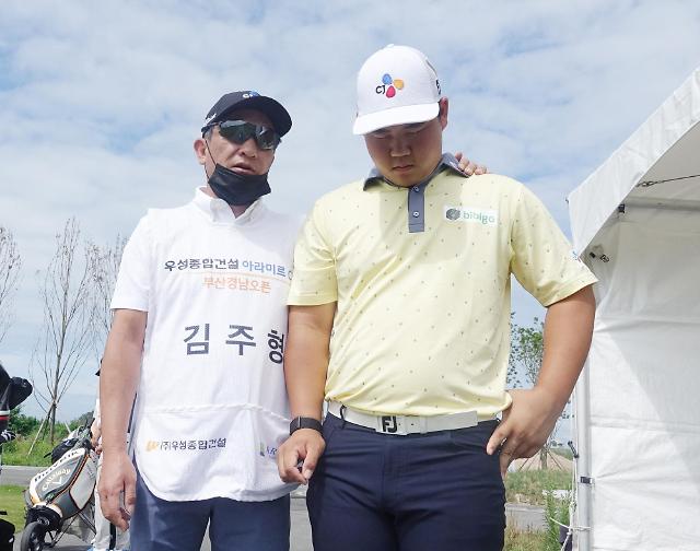 캐디를 자처한 아버지와 기도하는 김주형 (오른쪽)