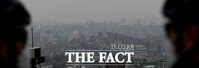 지난달 11일 서울 용산구 후암동에서 라이딩을 하던 두 남성이 미세먼지에 덮인 도심을 바라보고 있다.