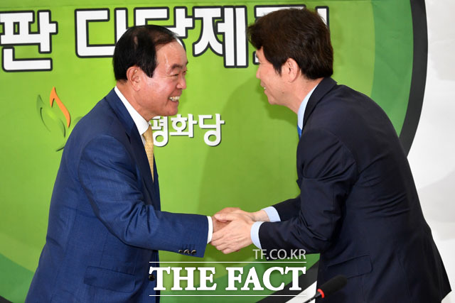 악수와 축하 전하는 장병완