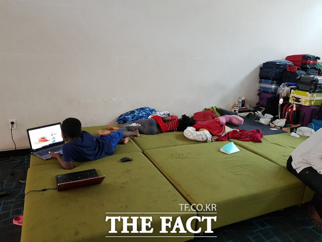 루렌도 가족은 인천국제공항 라운지에 이어 붙인 소파 위에서 숙식을 해결한다. 사진은 노트북을 하고 있는 3남 실로(왼쪽)와 간밤에 라운지가 유독 소란스러워 잠을 설쳤다는 막내딸 그라스(오른쪽). /인천국제공항=송주원 인턴기자