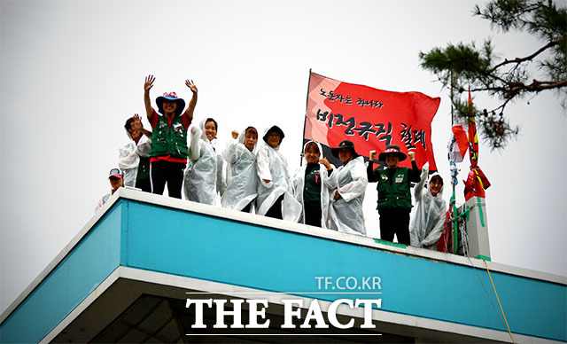 고공농성 노조원들이 동료들의 응원에 미소로 답하고 있다.