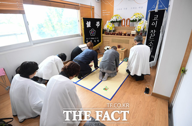 고인을 기리는 봉사자들의 기도.