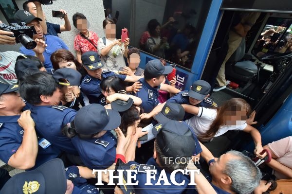 12일 제주지법에서 열린 고유정의 첫 공판이 끝나고 호송차에 오르는 고유정의 머리채를 시민들이 잡아 당기고 있다. /뉴시스