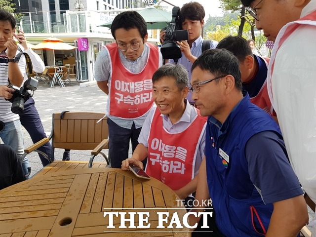 이상규 민중공동행동 대표(가운데)와 윤택근 전국민주노동조합총연맹 부위원장(오른쪽)이 29일 서울 서초구 대법원 앞에서 '국정농단 사태' 대법원 선고 중계방송을 보고 있다. /송주원 기자