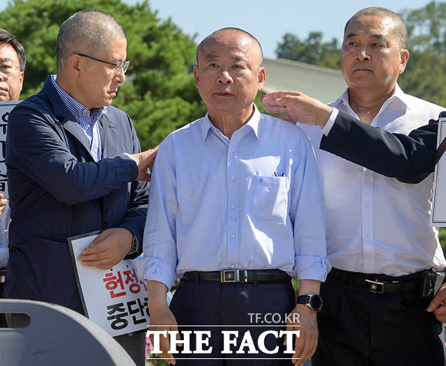 '민머리의 세 사람' 황교안 대표가 삭발을 마친 이 부의장의 어깨에 묻은 머리카락을 털어내고 있다. 이날 심재철 의원도 삭발에 동참했다.