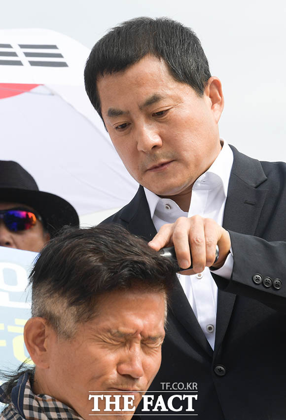 '눈 꼭 감고' 황 대표의 삭발식 다음날인 17일, 같은 자리에서 다음 주자로 김문수 전 경기도지사가 나섰다. 김 전 지사의 머리를 깎아 주는 사람은 바로 4개월 전 패스트트랙 사태 당시 삭발을 했던 박대출 자유한국당 의원.