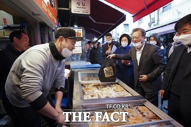 문 대통령은 18일 청와대에서 주재한 국무회의에서 중소기업·소상공인들에 대한 특별금융 지원 및 세 부담 완화 조치 등을 검토하라고 정부에 지시했다. 사진은 지난 12일 서울 중구 남대문시장을 방문해 어묵을 사는 문 대통령. /청와대 제공