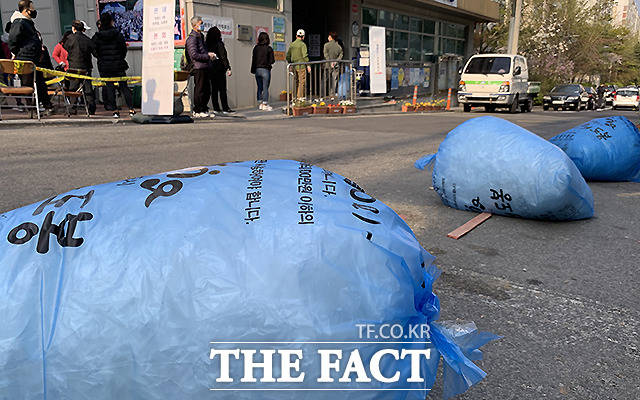 제 21대 국회의원선거 사전투표 마지막날인 11일 오후 서울 도봉구 쌍문 4동 주민센터에 마련된 사전투표소 앞에서 유권자들이 투표를 하기 위해 길게 줄 선 가운데, 유권자들이 사용하고 버려진 일회용 비닐장갑을 담은 쓰레기봉투가 곳곳에 쌓여 있다. /이새롬 기자