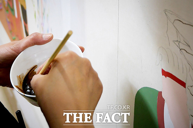 탱화엔 황(黃), 청(靑), 백(白), 적(赤), 흑(黑)의 다섯 가지 색이 사용되는데 이는 음양오행 사상에 기반을 둔 한국의 전통 오방색이다. 김송희 불모는 오방색 중 하나를 사용해 스케치 위에 정성스럽게 덧칠했다.