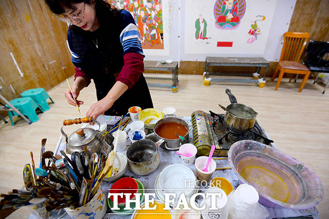 색 작업에 앞서 사용할 붓을 깨끗히 세척했다. 작업대 위에는 색을 만드는 안료와 깨끗한 물, 다양한 크기의 붓이 있었다.