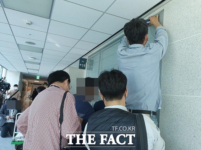 지난 1일 윤미향 의원 사무실인 국회 의원회관 530호실 앞에서 사진기자들이 블라인드 틈으로 윤 의원 얼굴 촬영을 시도하는 모습. /박숙현 기자