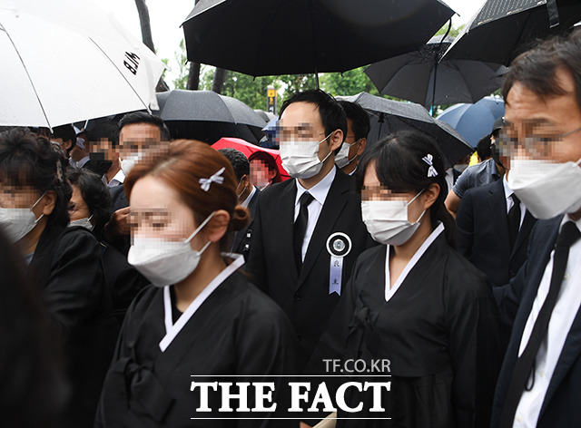 고 박원순 서울시장의 영정이 13일 오전 서울 중구 서울특별시청 앞 광장에 도착한 가운데 박 시장의 아들 주신 씨(가운데)가 유족들과 함께 영결식장으로 이동하고 있다. /배정한 기자