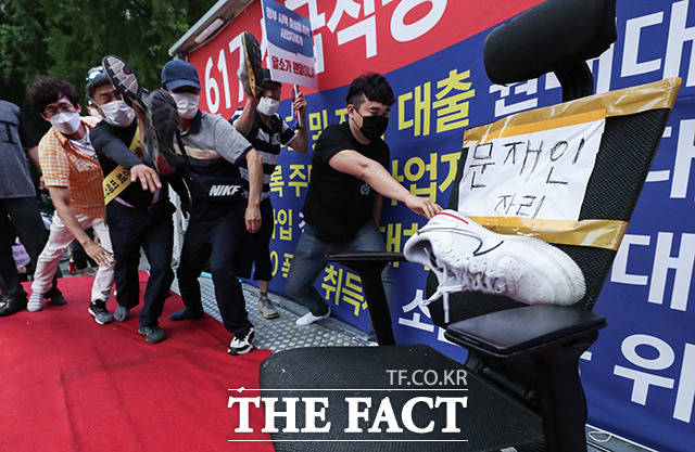 문재인 정부의 부동산 정책에 실망한 시민들이 을지로입구역 인근에서 촛불집회를 진행했다. 사진은 이날 참가자들이 문재인 대통령의 자리를 나타낸 의자를 향해 신발을 던지는 퍼포먼스를 하는 모습. /이동률 기자