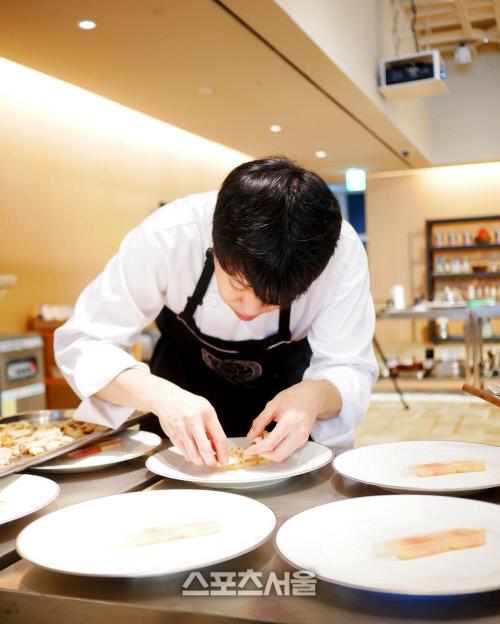 하얏트호텔의 더 굿 테이스트 시리즈에 참가한 파크 하얏트 서울 정상협 셰프가 복숭아를 올리며 플레이팅 중이다.