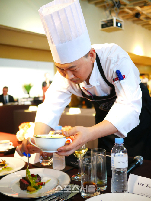 그랜드 하얏트 인천 선창호 셰프가 심사위원 앞에 놓인 플레이트에 소스를 끼얹어주고 있다.