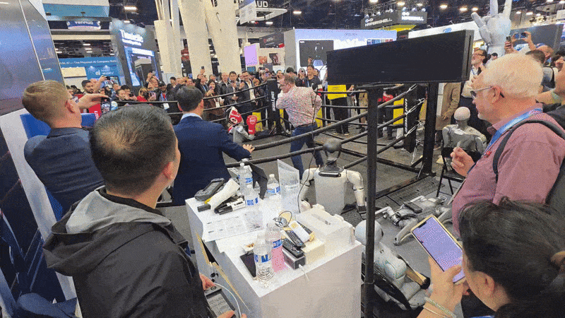 6일(현지시간) 세계 최대 정보통신(IT) 전시회 ‘CES 2026’이 열린 미국 라스베이거스 컨벤션센터(LVCC) 노스홀에 중국 로봇기업 ‘유니트리’의 복싱 로봇이 한 남성과 스파링을 하고 있다. 화면 중앙 아래에는 유니트리 관계자가 조이스틱을 활용해 로봇을 조종하고 있다. 오동욱 기자