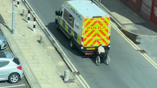 영국 맨체스터 도심에서 한 휠체어 이용자가 달리는 경찰 차량 뒤에 매달려 이동하는 장면이 포착돼 충격을 주고 있다. 틱톡 hussainzohib 캡처
