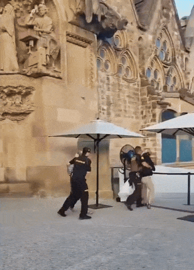 스페인 환경운동가들이 내년 완공 예정인 스페인 바르셀로나의 대표적 건축물 사그라다 파밀리아(성가족 성당) 기둥에 페인트(붉은 원)를 뿌렸다가 경비원에게 제지당하는 모습.  스페인 환경단체 ‘푸투로 베헤탈’ 엑스 캡처