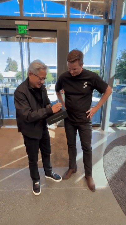 젠슨황 엔비디아 CEO(왼쪽)와 브렛 애드콕 피규어AI CEO가 나란히 서 있는 영상. 젠슨황 CEO가 선물 상자에 메시지를 적고 있다. [사진=브렛 애드콕 피규어AI CEO X계정]