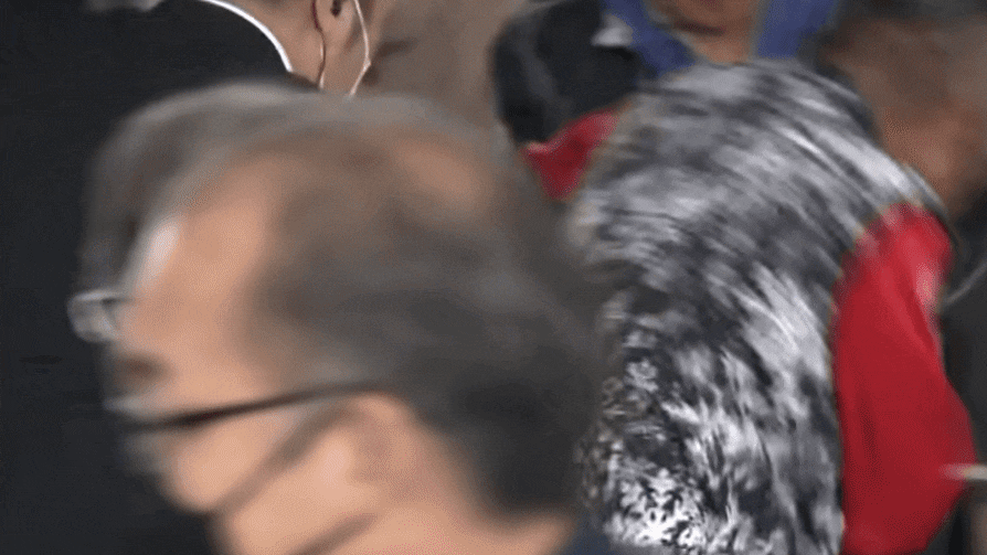 15일 오전 11시 30분쯤 일본 와카야마현 와카야마시에서 기시다 후미오 일본 총리를 겨냥한 폭발물 투척 사건이 발생한 가운데 빨간 상의를 입은 남성이 테러 용의자를 제압하고 있다./NHK