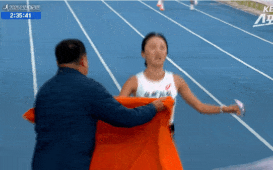 지난 23일 인천 송도국제도시에서 열린 '2025 인천국제마라톤' 여자 국내부 경기에서 1위로 골인한 삼척시청 이수민(가운데 오른쪽) 선수가 결승선을 통과하자 김완기 감독이 타월을 둘러주고 있다. KBS스포츠 유튜브 캡처