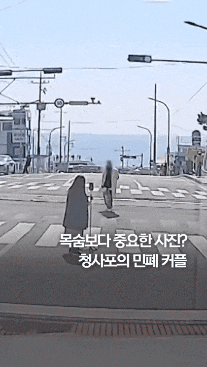 부산 해운대구 청사포 해변 인근 차로에서 기념 사진을 찍는 커플의 모습. [보배드림 갈무리]