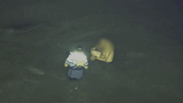 지난 11일 인천 옹진군 영흥도 갯벌에 고립된 중국 국적 남성에게 이재석 경사가 구명조끼를 벗어주는 모습. 인천해양경찰서 제공