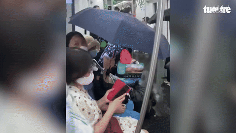 [뉴시스] 베트남 하노이의 한 지하철에서 에어컨 배수구 고장으로 객실 안으로 물이 쏟아지면서 승객들이 우산을 펼쳐 쓰고 있는 모습.(사진＝tuoitre) *재판매 및 DB 금지