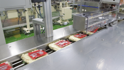 [밀양=뉴시스] 삼양식품 밀양2공장에서 불닭볶음면을 생산하는 모습. 모든 공정을 거친 면 상단에 소스를 투입하는 '포장'이 자동화로 이뤄지고 있다. (사진= 삼양식품 제공) photo@newsis.com