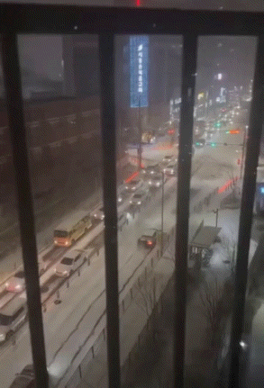 [뉴시스] 눈 내리는 오르막길에서 미끄러진 차량을 배달 기사들이 함께 밀어 올리는 장면이 공개돼 온라인에서 화제가 되고 있다. (사진='보배드림' 갈무리) *재판매 및 DB금지 *재판매 및 DB 금지